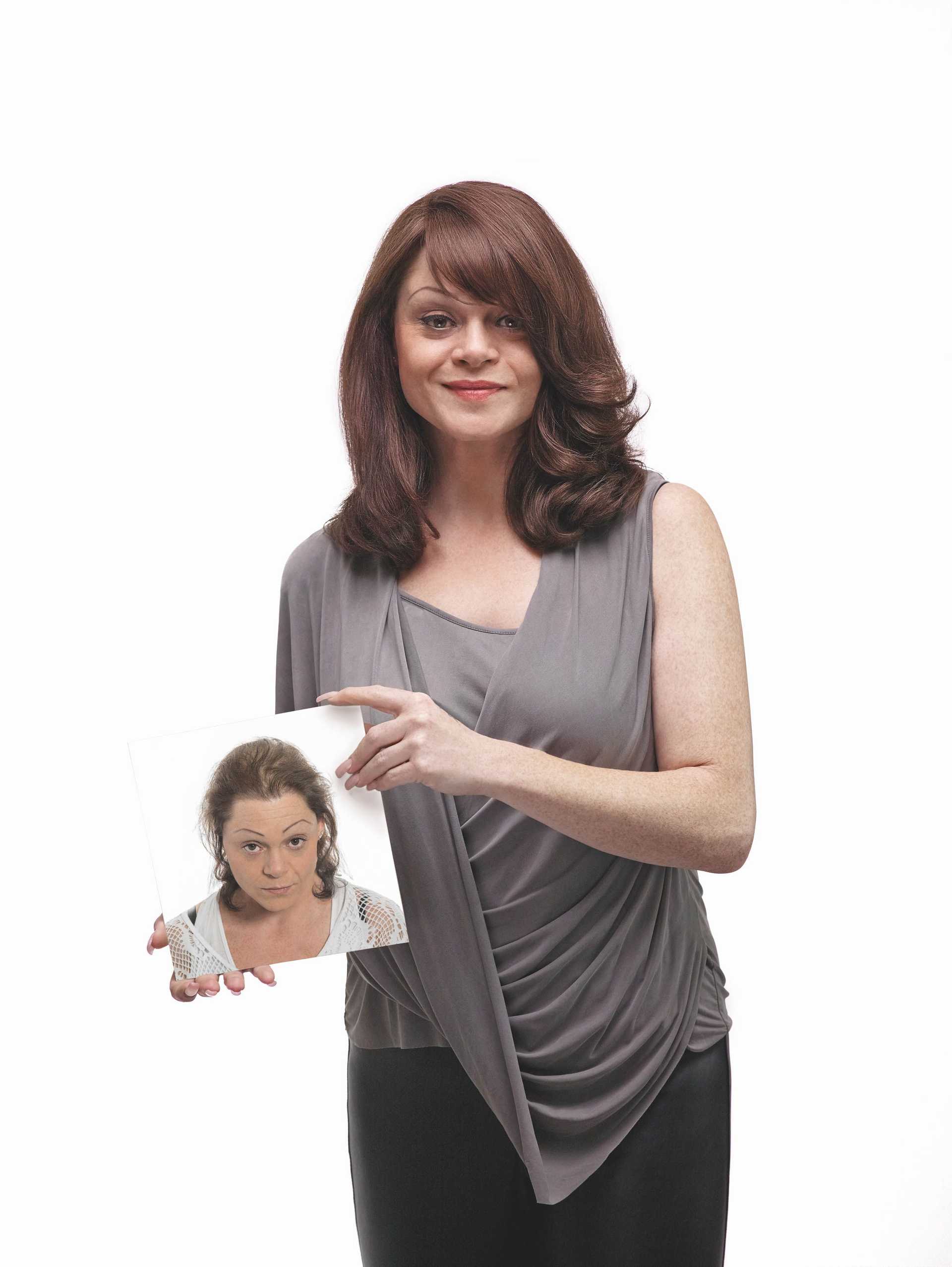 Woman holding a mirror reflecting herself with different expression.