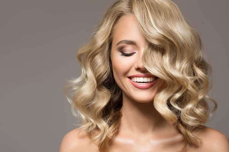 Smiling woman with wavy blonde hair.